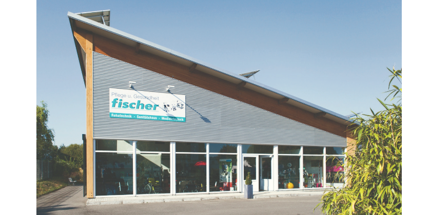 Geschäftshaus Fischer Moderne Geschäftshaus mit Glasfront und einem großen Schild "Fischer" an der Fassade.